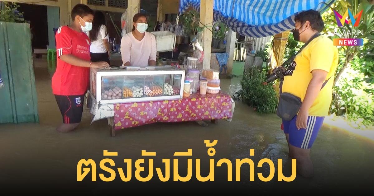 ตรัง น้ำยังท่วม แม่ค้าลูกชิ้น ใส่รองเท้าบู๊ต ผูกร้านไว้กับเสา กันคลื่นกระแทก